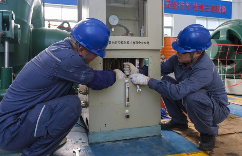 2.靖西供電公司工作人員在峒牌發(fā)電站對(duì)調(diào)整器進(jìn)行檢修維護(hù)。駱衍利攝.JPG